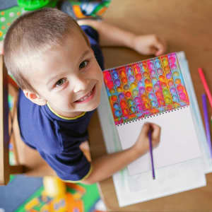 A5 Pop Bubble Fidget Notebook featuring colourful pop bubbles on the cover, with a child using it to draw.