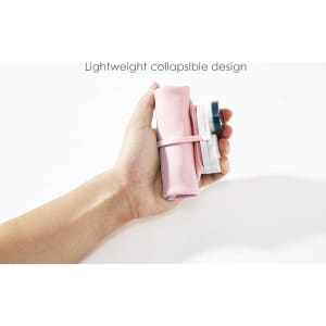 A drink bottle in pink and grey with a collapsible design, held in a hand against a white background.