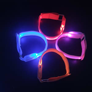 A set of LED bracelets in blue, red, pink, and orange, featuring metal clasps and illuminated sections.