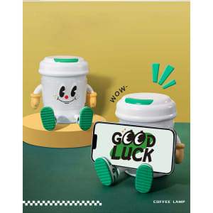 A coffee cup-shaped lamp Bluetooth speaker in white with green accents, featuring a character design and a mobile phone.