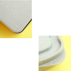 A wheat straw bread box in light green with a speckled design, featuring a subtle logo on the lid.