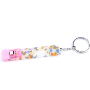 A keychain featuring a colourful, speckled design with a pink clip and a silver keyring.