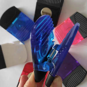 A wide rectangle clip in blue, surrounded by clips in red, purple, black, and white, all featuring a logo.