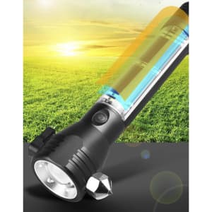 A black flashlight with a transparent power bank section, set against a grassy background and bright sky. It features a logo.