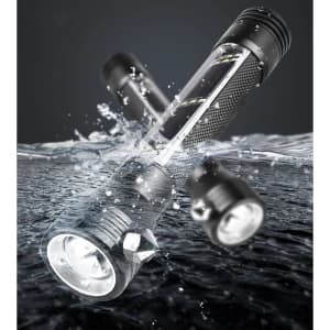 A sleek black flashlight lies above water, showcasing its durable design and LED light. It features a logo on the body.