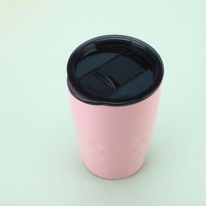 A pink travel tumbler with a black lid, featuring a textured design suitable for beverages.