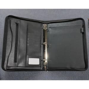 A black ring binder with multiple pockets, a zippered compartment, and a silver metal ring mechanism.