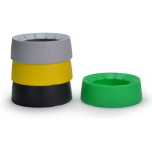 A stack of four coasters in grey, yellow, black, and green, with one green coaster positioned separately.