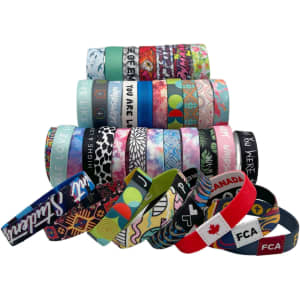 A variety of vibrant 1'' RPET elastic wristbands in different colours and patterns, with several featuring logos.