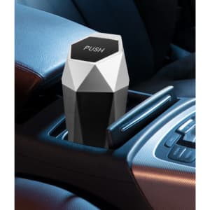 A geometric black and white car trash can sits in a car's cup holder, featuring a 'PUSH' top and a sleek design.