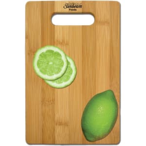 A bamboo cutting board with a handle cutout, featuring lime slices and a whole lime, and displaying a logo.