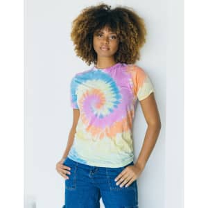 A tie-dye adult t-shirt in pastel colours, featuring a spiral design. A model poses while leaning against a wall.