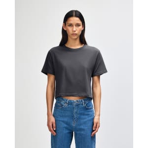 A grey women's boxy t-shirt with short sleeves, featuring a round neckline and a logo on the side.