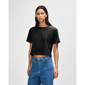 A black women's fine jersey boxy T-shirt displayed on a model, featuring a simple design and relaxed fit.