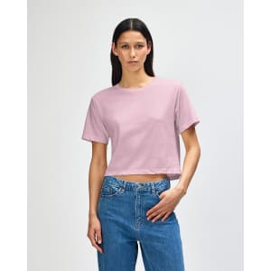 A boxy T-shirt in soft pink, featuring short sleeves and a relaxed fit, with a subtle branding on the front.
