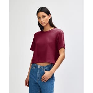 A maroon women's fine jersey boxy t-shirt displayed on a model with curly hair, featuring a casual fit.