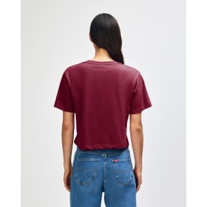 A maroon women's fine jersey boxy T-shirt, viewed from the back, paired with light blue baggy jeans.