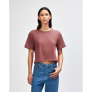 A women's boxy T-shirt in rose colour, featuring short sleeves and a relaxed fit, with a logo on the brand.