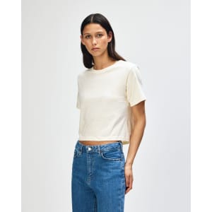 A women's fine jersey boxy t-shirt in cream, paired with light blue jeans, featuring a branding logo.