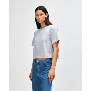 A grey women's fine jersey boxy T-shirt, featuring short sleeves and a cropped design, displayed on a model in profile.