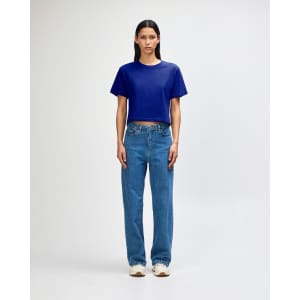 A blue boxy T-shirt paired with light blue cargo jeans and sneakers, displayed on a model. The outfit features casual styling.