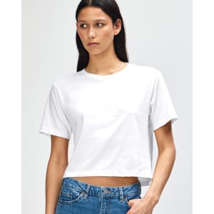 A white women's fine jersey boxy t-shirt displayed on a model, featuring a minimalistic design and an attached logo.