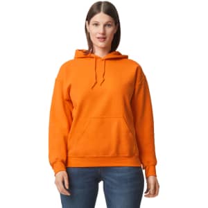 An orange hooded sweatshirt with a front pocket and drawstring hood, worn by a model. Features a logo.