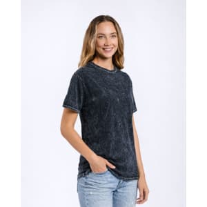 A dark mineral wash adult t-shirt featuring a relaxed fit and short sleeves, displayed by a smiling model.
