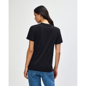 A black heavyweight cotton unisex T-shirt displayed on a model from the back, featuring a simple design and loose fit.