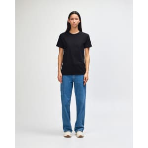 A black heavyweight cotton unisex T-shirt displayed on a model, paired with green cargo pants and sneakers.
