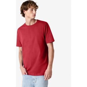 A red heavyweight cotton unisex T-shirt on a model wearing light blue jeans, with a logo on the shirt.