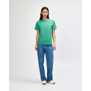 A green heavyweight cotton unisex T-shirt displayed on a model, paired with light blue cargo pants.