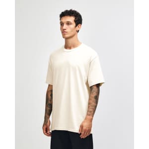 A heavyweight cotton unisex t-shirt in cream, displayed on a model with a neutral background.