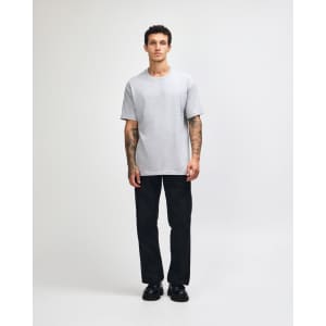 A plain grey heavyweight cotton unisex T-shirt displayed on a model, paired with olive green trousers.
