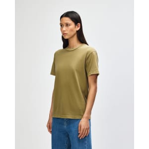 A heavyweight cotton unisex T-shirt in olive green, displayed on a model with curly hair. It features a simple design and branding.