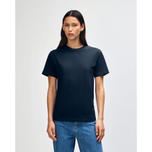 A unisex heavyweight cotton t-shirt in black, displayed on a model with straight black hair, paired with blue jeans.