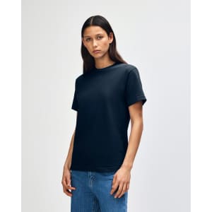 A heavyweight cotton unisex t-shirt in black, displayed on a model with straight hair and denim jeans.