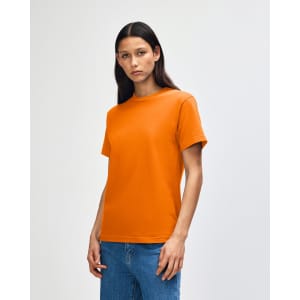 An orange heavyweight cotton unisex T-shirt on a model, paired with light blue jeans.