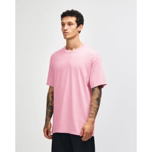 A pink heavyweight cotton unisex T-shirt displayed on a model, featuring a relaxed fit and short sleeves.