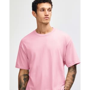 A unisex heavyweight cotton t-shirt in pink, featuring a round neckline and short sleeves. It has a logo.