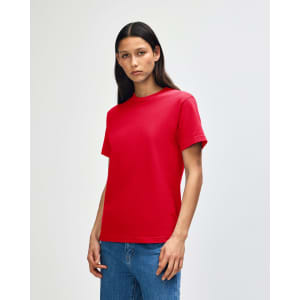 A red heavyweight cotton unisex T-shirt worn by a model, featuring a plain design and a logo.