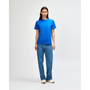 A model wearing a bright blue heavyweight cotton unisex T-shirt paired with light blue jeans.