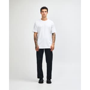 A lightweight white unisex T-shirt displayed on a model wearing baggy blue jeans and black sneakers, featuring a logo.