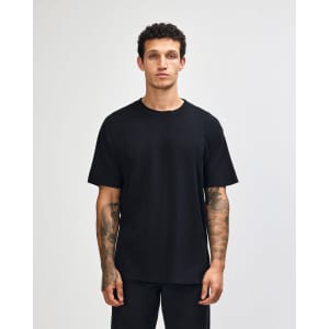 A unisex heavyweight cotton T-shirt in black, featuring a relaxed fit and a round neck. Includes a logo detail.