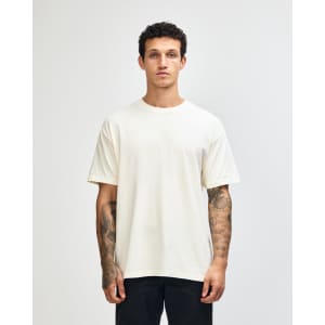 An unisex heavyweight cotton T-shirt in a light cream colour, featuring a simple design and a logo.