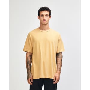 A unisex heavyweight cotton t-shirt in a soft yellow colour, featuring a relaxed fit and short sleeves.