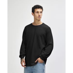 A black heavyweight cotton unisex long sleeve T-shirt worn by a model, featuring a simple design and a logo.