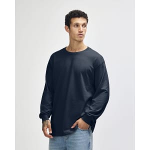 A black unisex long sleeve t-shirt displayed on a model, featuring a relaxed fit and a logo on the chest.