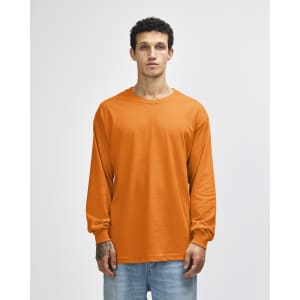 An orange heavyweight cotton unisex long sleeve t-shirt displayed on a model, featuring a logo.