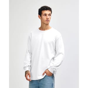 A white heavyweight cotton unisex long sleeve T-shirt displayed on a model, featuring a simple design and branding.